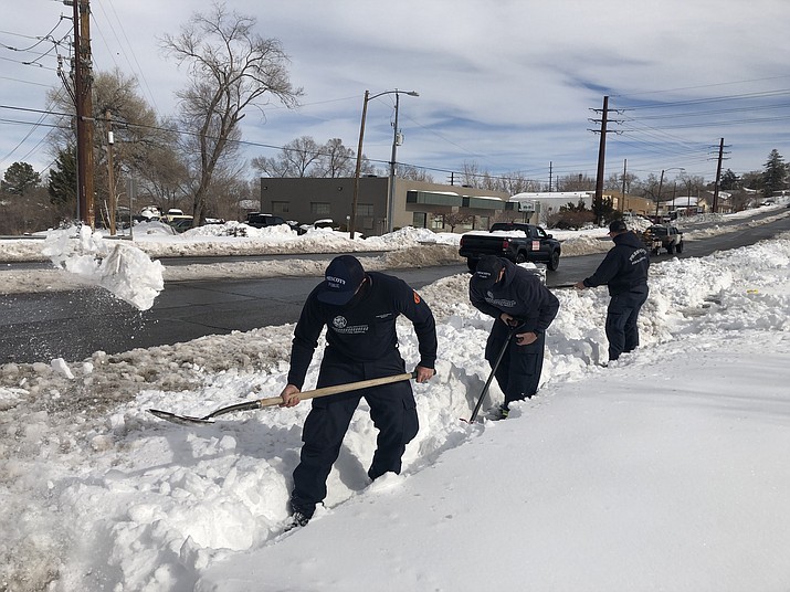 Prescott firefighters Jordan Pluimer, Jeff Archer and Tye Seets work to clear snow from the sidewalk in front of the city’s White Spar Road Station on Thursday, Jan. 28, 2021. They were among the many Prescott residents and business people who were digging out from the massive snowstorm earlier this week. (Cindy Barks/Courier)