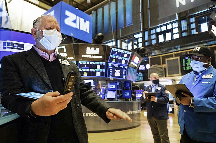 In this photo provided by the New York Stock Exchange, Robert Moran, left, works with fellow traders on the floor, Tuesday Feb. 2, 2021. Stocks were broadly higher in afternoon trading Tuesday, but shares of closely watched companies like GameStop and AMC Entertainment were falling sharply. (Colin Ziemer/New York Stock Exchange via AP)