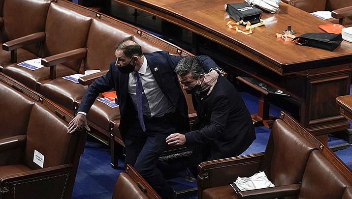 A lawmaker is rushed from the floor in the U.S. Capitol during an attack by rioters on Jan. 6. Former President Donald Trump was acquitted by the U.S. Senate on Saturday, Feb. 13 for his role in the melee. (AP file photo)