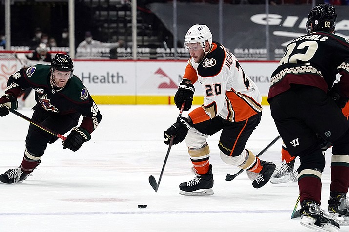 Anaheim Ducks left wing Nicolas Deslauriers (20) carries the puck between Arizona Coyotes defenseman Jordan Oesterle (82) and right wing Christian Fischer (36) during the first period of an NHL hockey game Wednesday, Feb. 24, 2021, in Glendale.(Rick Scuteri/AP)