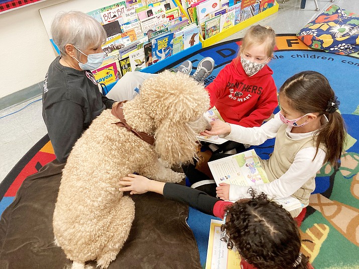 First-graders Ava Butler, Jessica Kaawaloa and Alexandrea Williams (left to right) read with Bailey, a dog with the Pet Partners of Prescott. (Nanci Hutson/Courier)