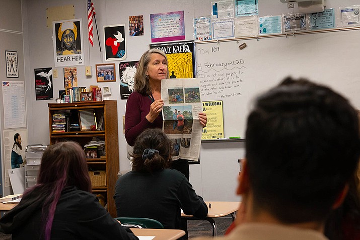 Kim Klett, a teacher at Dobson High School, holds up a newspaper story about Rwandan genocide during her Holocaust literature class on Tuesday, February 4, 2020. She believes it’s important to teach about more genocides than just the Holocaust. “(The Holocaust) is something that's still enough in our recent history,” she said. “The connections that are made between the two. So I think it’s a good starting point . . .We have to teach about other genocides in addition.” (Delia Johnson/Cronkite News)