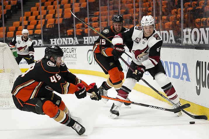 Arizona Coyotes' Jakob Chychrun, right, moves the puck as he is pressure by Anaheim Ducks' Max Jones, left, and Ryan Getzlaf during the second period of an NHL hockey game Saturday, March 20, 2021, in Anaheim, Calif. (Jae C. Hong/AP)