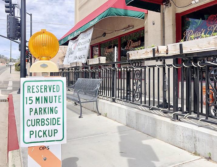 In this April 2020 file photo, Rosa’s Pizzeria in downtown Prescott put up signs that reserve parking spaces for curbside pickups, as well as a banner that alerted customers to the takeout and curbside services currently being offered. The City of Prescott on Tuesday, April 6, 2021, announced that it is rescinding its sign code moratorium April 15.  (Cindy Barks/Courier, file)