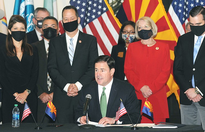 Surrounded by legislators, Gov. Doug Ducey on Thursday explains how he believes the benefits of the new tribal gaming compacts being signed outweigh any drawbacks. (Capitol Media Services photo by Howard Fischer)
