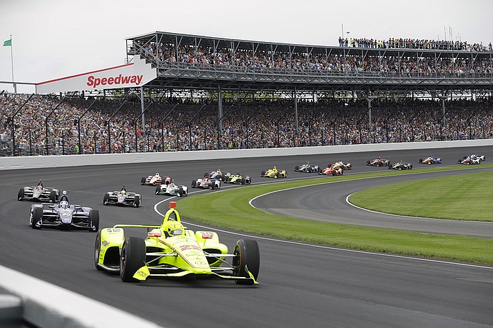 In this May 26, 2019, file photo, Simon Pagenaud, of France, leads the field through the first turn on the start of the Indianapolis 500 IndyCar auto race at Indianapolis Motor Speedway in Indianapolis. The Indianapolis 500 will be the largest sporting event since the start of the pandemic with 135,000 spectators permitted to attend “The Greatest Spectacle in Racing” next month. Indianapolis Motor Speedway said Wednesday, April 21, 2021, it worked with the Marion County Public Health Department to determine 40% of venue capacity can attend the May 30 race. (Darron Cummings, AP File)