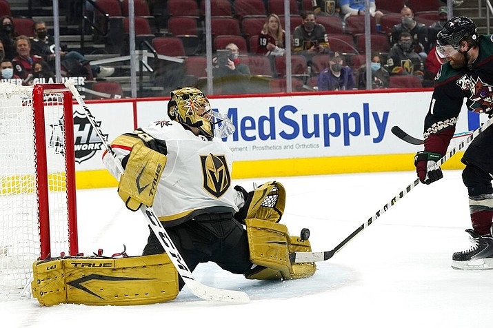 Vegas Golden Knights goaltender Marc-Andre Fleury, left, makes a save on a shot from Arizona Coyotes right wing Phil Kessel, right, during the first period of an NHL hockey game Saturday, May 1, 2021, in Glendale, Ariz. (AP Photo/Ross D. Franklin)