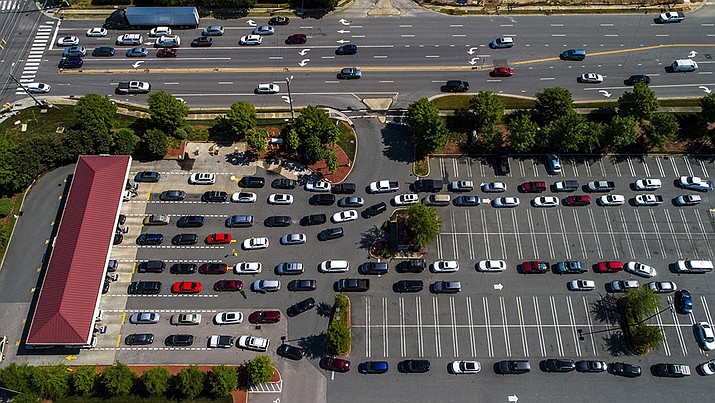 Vehicles wait in lines at the Costco in Raleigh, N.C., Thursday, May 13, 2021.  Operators of the Colonial Pipeline say they began the process of moving fuel through the pipeline again on Wednesday, six days after it was shut down because of a cyberattack.  (Travis Long/The News & Observer via AP)