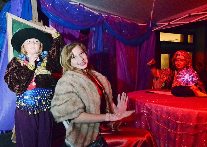 Jerome resident Carol Anne Teague reads the fortune of her granddaughter, Tyler Teague, center, while Harlequin Teague, also her granddaughter, assists. Fortune telling is one of the many aspects of Jerome as a ghost town. VVN/Vyto Starinskas