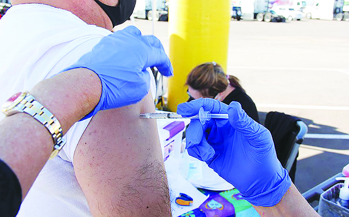 A Bashas’ worker gets a dose of the Johnson & Johnson vaccine during an event in March. Vaccination rates have fallen sharply from a high of more than 75,000 a day in early April to fewer than 10,000 doses on some recent days, but state health officials still hope to hit a CDC goal of 70% of people vaccinated by July 4. (Travis Robertson/Cronkite News)