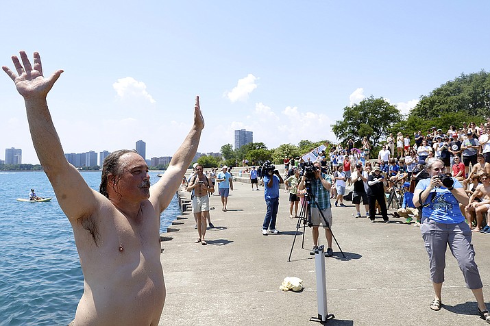 Dan O'Conor, the "Great Lake Jumper," reacts after making his 365th leap into Lake Michigan, Saturday, June 12, 2021, in Chicago's Montrose Point. (AP Photo/Shafkat Anowar)