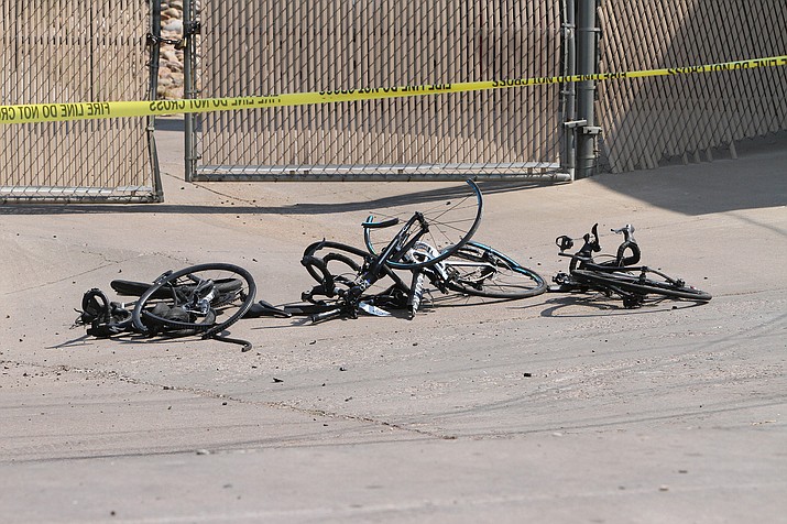 This Saturday, June 19, 2021, photo courtesy of The White Mountain Independent shows the scene of an accident with broken bicycles in Show Low, Ariz. A driver in a pickup truck plowed into bicyclists competing in a community road race in Arizona on Saturday, critically injuring several riders before police chased down the driver and shot him outside a nearby hardware store, police said. (Jim Headley/The White Mountain Independent via AP)