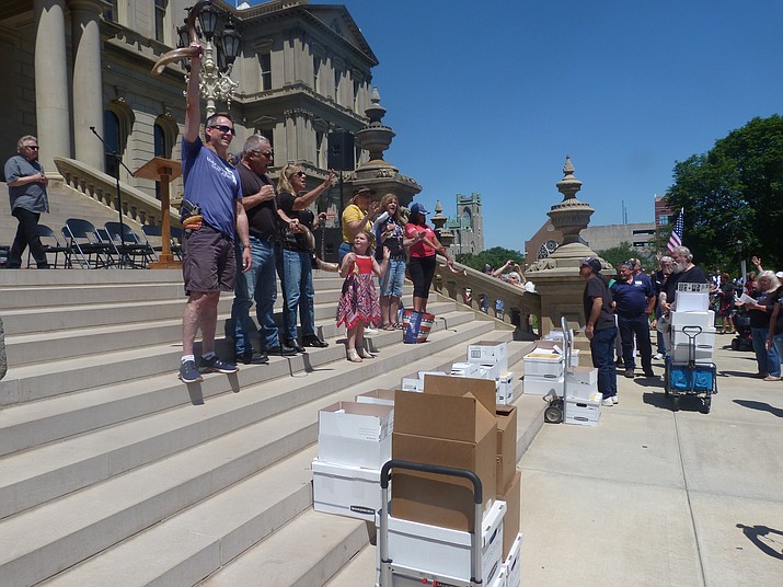In this June 17, 2021 photo, conservatives gather on the steps of the Michigan Capitol before delivering thousands of affidavits requesting that lawmakers order an "forensic" audit of the 2020 election in Lansing, Mich. Senate Republicans who investigated Michigan's presidential election say there was no widespread or systemic fraud in a report Wednesday, June 23, 2021. (David Eggert/AP, File)