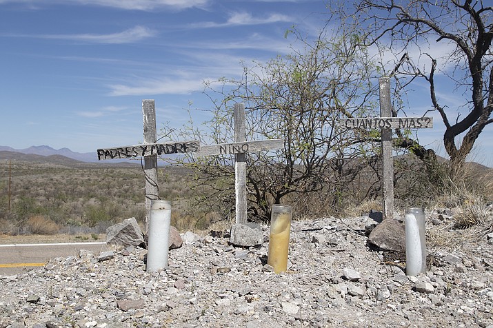 Three wooden crosses mark the location where the remains of a family were found near Arivaca in April. They were among a record-setting 127 migrant remains recovered in the Arizona desert in the first six months of this year. (File photo by Grace Oldham/Cronkite Borderlands Project)