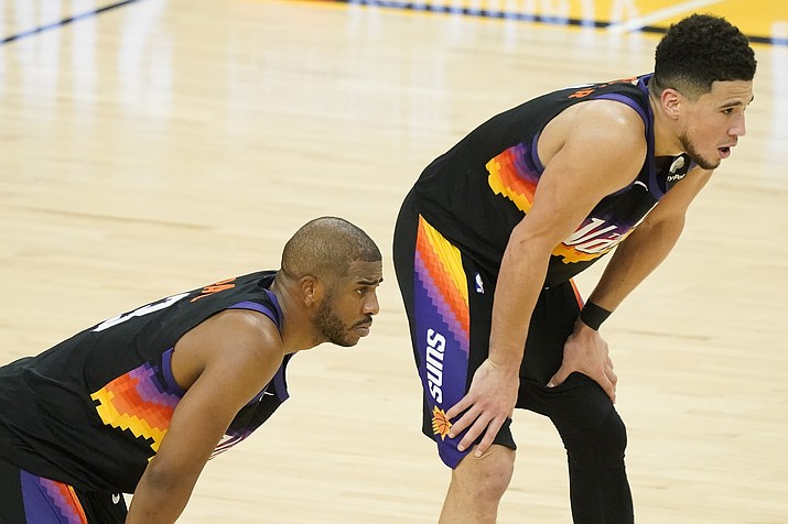Phoenix Suns guard Chris Paul, left, stands next to guard Devin Booker during the second half of Game 5 of basketball's NBA Finals against the Milwaukee Bucks, Saturday, July 17, 2021, in Phoenix. (Matt York/AP)