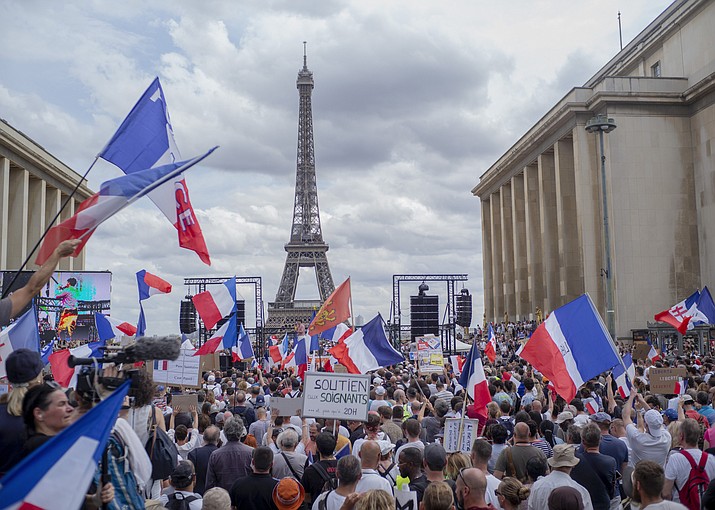 Thousands of protesters gather at Place Trocadero near the Eiffel Tower attend a demonstration in Paris, France, Saturday July 24, 2021, against the COVID-19 pass which grants vaccinated individuals greater ease of access to venues. (Rafael Yaghobzadeh/AP)