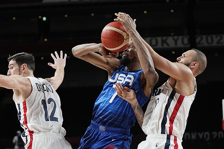 United States' forward Kevin Durant (7) and France's Evan Fournier, right, fight for control of the ball during a men's basketball preliminary round game at the 2020 Summer Olympics, Sunday, July 25, 2021, in Saitama, Japan. (Eric Gay/AP)