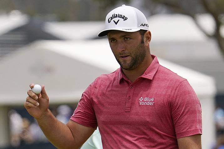 In this June 20, 2021, photo, Jon Rahm, of Spain, waves after his putt on the first green during the final round of the U.S. Open Golf Championship at Torrey Pines Golf Course in San Diego. Rahm has tested positive for COVID-19 for the second time in two months and the Spaniard has been knocked out of the Olympics only a few hours after American golfer Bryson DeChambeau met the same fate. (Gregory Bull/AP, File)