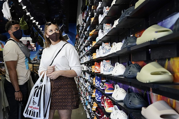 In this Monday, July 19, 2021, photo, shoppers wear masks inside of The Cool store in the Fairfax district of Los Angeles. The Centers for Disease Control and Prevention reversed course Tuesday, July 27, 2021, on some masking guidelines, recommending that even vaccinated people return to wearing masks indoors in parts of the U.S. where the coronavirus is surging. (Marcio Jose Sanchez/AP, File)