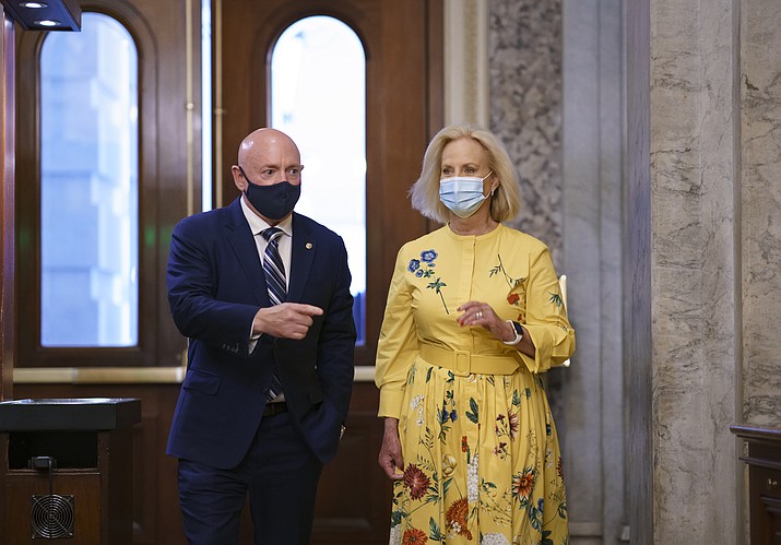 Sen. Mark Kelly, D-Ariz., is joined by Cindy McCain, right, the widow of the late Senator John McCain of Arizona, as Kelly arrives to deliver his maiden speech to the Senate, at the Capitol in Washington, Wednesday, Aug. 4, 2021. (J. Scott Applewhite/AP)
