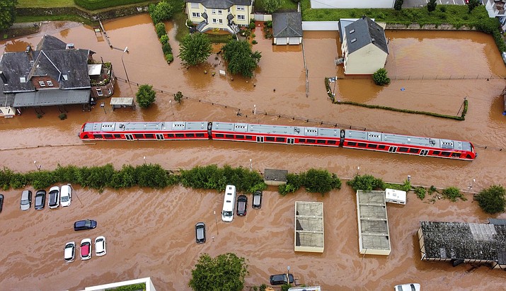 In this Thursday, July 15, 2021, 2021 photo, a regional train in the flood waters at the local station in Kordel, Germany, after it was flooded by the high waters of the Kyll river. This summer a lot of the places hit by weather disasters are not used to getting extremes and many of them are wealthier, which is different from the normal climate change victims. That includes unprecedented deadly flooding in Germany and Belgium, 116-degree heat records in Portland, Oregon and similar blistering temperatures in Canada, along with wildfires. Now Southern Europe is seeing scorching temperatures and out-of-control blazes too. And the summer of extremes is only getting started. Peak Atlantic hurricane and wildfire seasons in the United States are knocking at the door. (Sebastian Schmitt/dpa via AP, File)