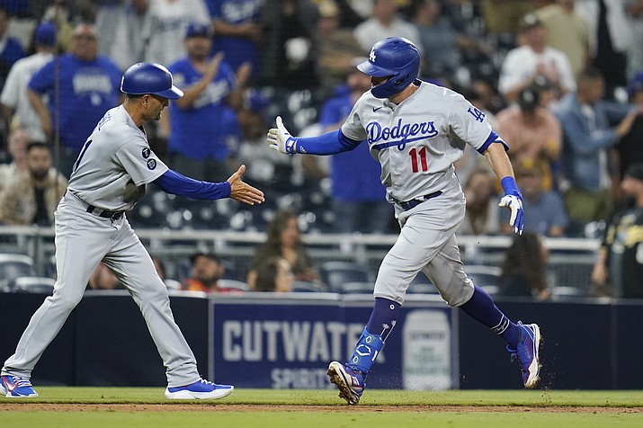 Los Angeles Dodgers' AJ Pollock, right, reacts with third base coach Dino Ebel after hitting a two-run home run during the sixteenth inning of a game against the San Diego Padres, Thursday, Aug. 26, 2021, in San Diego. (Gregory Bull/AP)