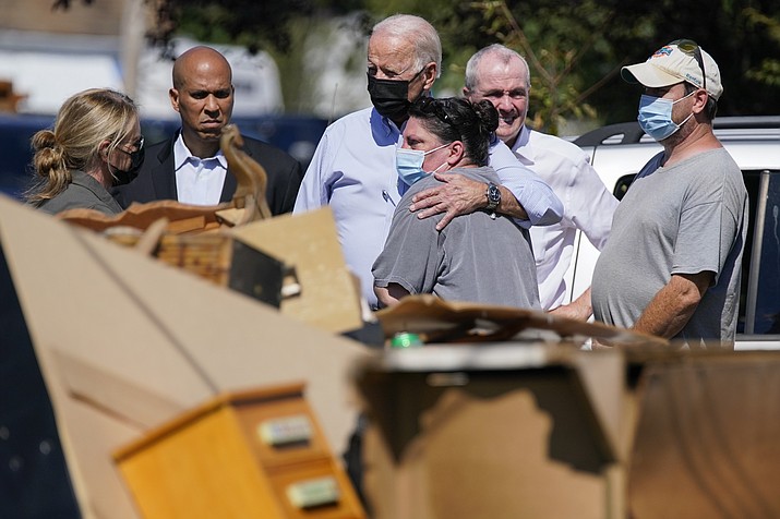President Joe Biden hugs a person as he tours a neighborhood impacted by Hurricane Ida, Tuesday, Sept. 7, 2021, in Manville, N.J. Sen. Cory Booker, D-N.J., second from left, and New Jersey Gov. Phil Murphy, second from right, look on. (Evan Vucci/AP)