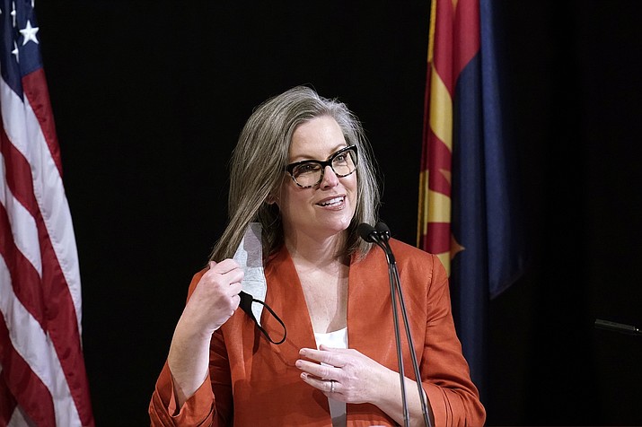 In this Dec. 14, 2020, file photo, Arizona Secretary of State Katie Hobbs removes her face mask as she addresses the members of Arizona's Electoral College prior to them casting their votes, in Phoenix. Hobbs is proposing to require county officials to count votes for certain offices even if the person shows up at the wrong precinct. So votes for president and statewide offices would be tallied despite being cast at the wrong polling location. (Ross D. Franklin/AP, file)