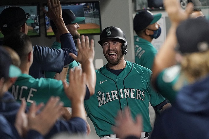 Seattle Mariners' Tom Murphy reacts in the dugout after hitting a two-run home run to also score Luis Torrens during the second inning of a baseball game against the Arizona Diamondbacks, Friday, Sept. 10, 2021, in Seattle. (Ted S. Warren/AP)