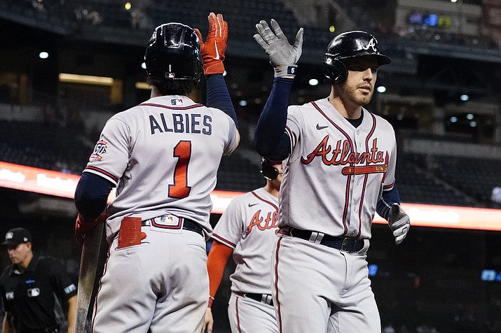 Atlanta Braves' Freddie Freeman high fives Ozzie Albies (1) after hitting a two run home run during the ninth inning of a game, Wednesday, Sept. 22, 2021, in Phoenix. (Matt York/AP)