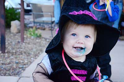 This 2015 file photo shows a little girl enjoying candy at the annual Trunk or Treat event in Camp Verde. The Camp Verde Parks and Recreation Department announced advance planning for the annual Main Street Trunk or Treat Halloween Festival, stating the event will be Sunday, Oct. 31, this year from 5 to 7 p.m. Main Street will be closed down from ACE Hardware to the Camp Verde Feed Store to allow for a safe environment for families to enjoy the activities. (Independent file photo)