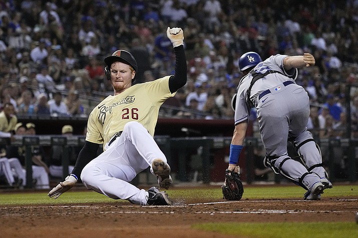 Arizona Diamondbacks' Pavin Smith (26) scores a run behind Los Angeles Dodgers catcher Will Smith on a ball hit by Josh VanMeter in the fifth inning during a baseball game, Friday  in Phoenix. (Rick Scuteri/AP)