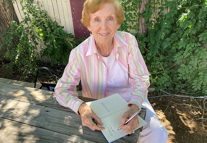 Denelle Harris signing her book, “Keys to Kindness – My True Stories” published in 2019. Holding up her book. Harris, a certified life coach, is the longtime instructor of an independent course started through the Yavapai College Osher Lifelong Learning Institute (OLLI) titled “Wise Women Gathering.” (Nanci Hutson/Courier)
