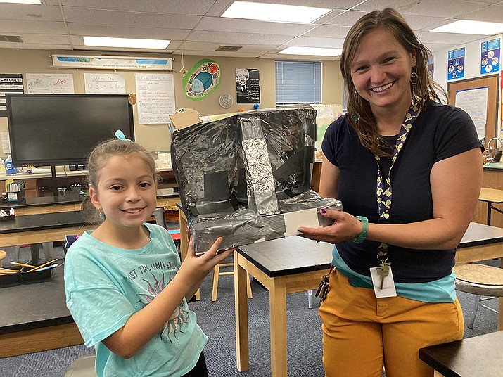 Granite Mountain STEAM teacher Elise Corcoran-Anderson holds up a space oven that the students created as part of their space exploration classes. Adelade Verna stands on the other side. Students tested the effectiveness of the oven by toasting S’mores. Nanci Hutson/Courier)