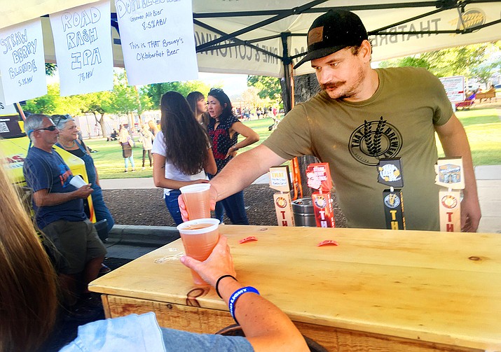 Sean Morris pours some cold ones at the That Brewery booth at the Clarktoberfest celebration in Clarkdale on Saturday, Oct. 2, 2021. Clarkdale’s fall festival and is an annual street fair and had live music with Sister and the Sun, local breweries and food vendors. (Vyto Starinskas/Independent)