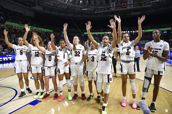 In this March 6, 2020 photo, South Carolina players celebrate after defeating Georgia 89-56 in a quarterfinal match at the Southeastern women's NCAA college basketball tournament in Greenville, S.C. Dawn Staley and South Carolina are back in a familiar spot: No. 1 in The Associated Press Top 25 women's basketball poll, released Tuesday, Oct. 19, 2021. (Richard Shiro/AP, File)