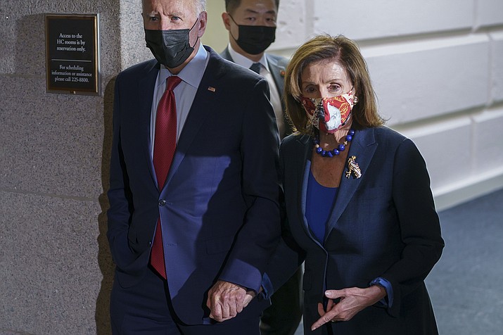 In this Oct. 1, 2021 photo, President Joe Biden and Speaker of the House Nancy Pelosi, D-Calif., walk in a basement hallway of the Capitol after meeting with House Democrats, on Capitol Hill in Washington. (J. Scott Applewhite/AP, file)
