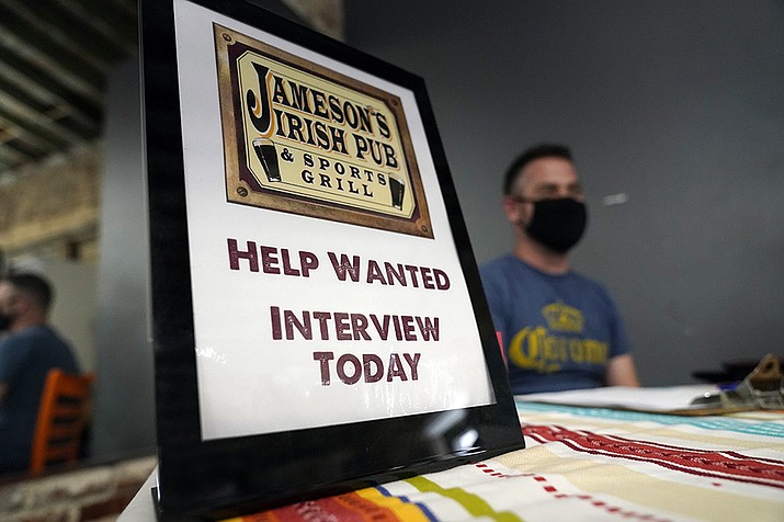 A hiring sign is placed at a booth for Jameson’s Irish Pub during a job fair Wednesday, Sept. 22, 2021, in the West Hollywood section of Los Angeles. Americans quit their jobs at a record pace for the second straight month in September, while businesses and other employers continued to post a near-record number of available jobs.(Marcio Jose Sanchez/AP, File)