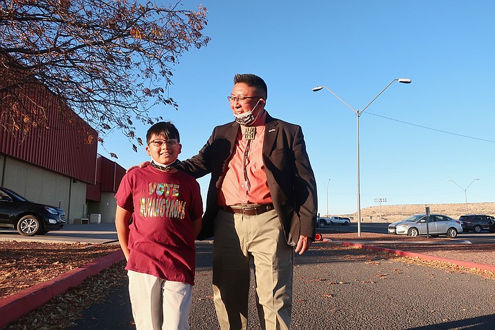 Hopi Chairman Tim Nuvangyaoma, walks out of the tribe's high school with his son in Polacca, Arizona, Nov. 6. The general election was held Nov. 11. (AP Photo/Felicia Fonseca)