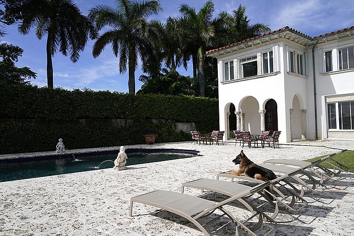 German Shepherd Gunther VI sits by the pool at a house formally owned by pop star Madonna, Monday, Nov. 15, 2021, in Miami. Gunther VI inherited his vast fortune, including the 9-bedroom waterfront home once owned by the Material Girl from his grandfather Gunther IV. The estate, purchased 20 years ago from the pop star, was listed for sale Wednesday. (Lynne Sladky/AP)