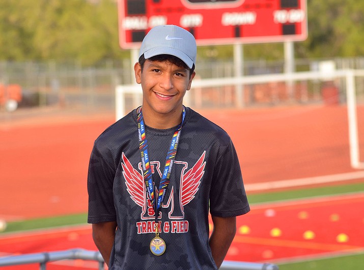 Junior Cesar Diaz at the Mingus Union High School track in Cottonwood on Thursday, Nov. 19, 2021, with his Division III State Championship cross-country medal. (Vyto Starinskas/Independent)