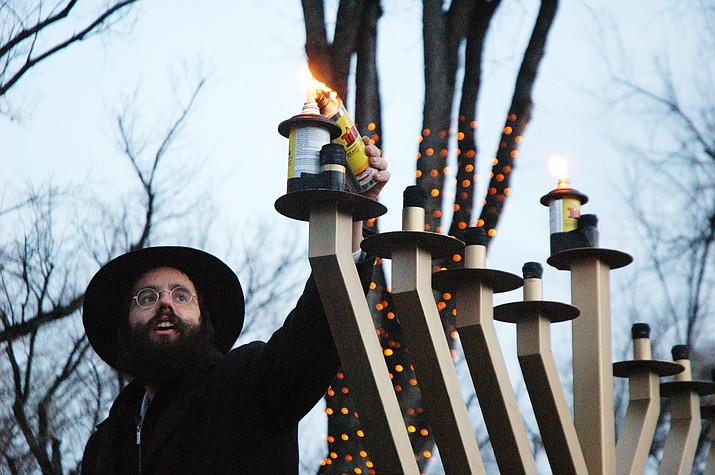 Rabbi Elie Filler of Chabad of Prescott lights a giant menorah on the courthouse plaza in celebration of the first night of Hanukkah. Chabad of Prescott will have a 2021 public menorah lighting on Sunday, Nov. 28. (Courier file photo)