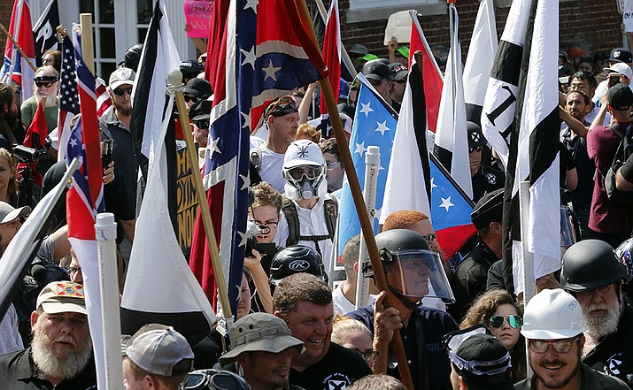 White nationalist demonstrators walk into the entrance of Lee Park surrounded by counter demonstrators in Charlottesville, Va., Saturday, Aug. 12, 2017. A jury began deliberations Friday, Nov. 19, 2021, in a civil trial of white nationalists accused of conspiring to commit racially motivated violence at the deadly “Unite the Right” rally in Charlottesville in 2017.(Steve Helber/AP)
