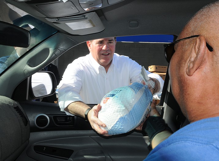Gov. Doug Ducey helps distribute free turkeys on Monday, Nov. 22, 2021, at American Legion Post 65 in Phoenix. (Howard Fischer/Capitol Media Services)