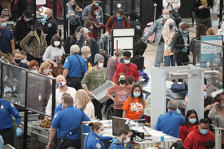 Travelers queue up at the south security checkpoint as traffic increases with the approach of the Thanksgiving Day holiday Tuesday, Nov. 23, 2021, at Denver International Airport in Denver. (David Zalubowski/AP)