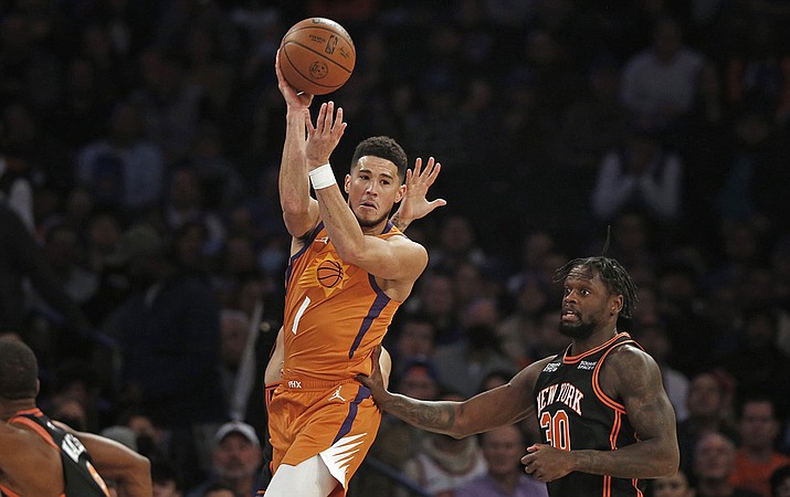 Phoenix Suns' Devin Booker (1) looks to pass over New York Knicks' Julius Randle (30) during the first half of an NBA basketball game Friday, Nov. 26, 2021, in New York. (John Munson/AP)
