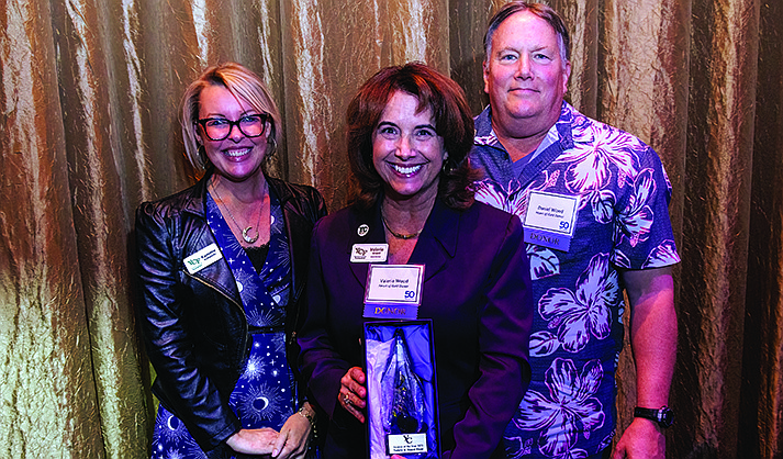 Valerie Wood (center) and Daniel Wood of Heart Wood Cellars receive an Alumni of the Year trophy from Kammie Kobyleski, director of Alumni Relations for Yavapai College. (YC/Courtesy)