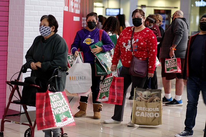 Black Friday shoppers wearing face masks wait in line to enter a store at the Glendale Galleria in Glendale, Calif., Friday, Nov. 27, 2020. Retailers are expected to usher in the unofficial start to the holiday shopping season Friday, Nov. 26, 2021, with bigger crowds than last year in a closer step toward normalcy. But the fallout from the pandemic continues to weigh on businesses and shoppers’ minds. (Ringo H.W. Chiu/AP, File)
