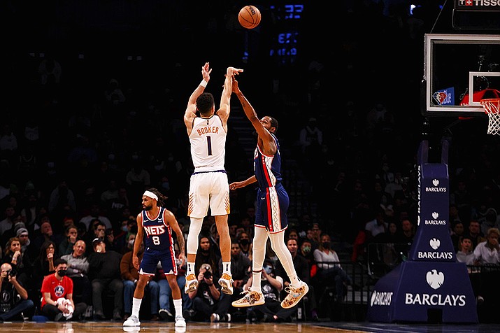 Phoenix Suns guard Devin Booker (1) shoots against Brooklyn Nets forward Kevin Durant (7) during the first half of an NBA basketball game, Saturday, Nov. 27, 2021, in New York. (Jessie Alcheh/AP)