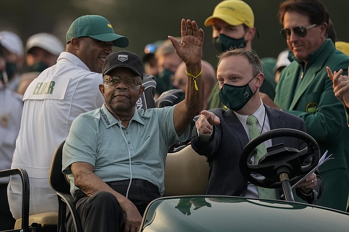 Lee Elder waves as he arrives for the ceremonial tee shots before the first round of the Masters golf tournament on Thursday, April 8, 2021, in Augusta, Ga. At far right is Phil Mickelson. Person at right in cart is unidentified. Elder broke down racial barriers as the first Black golfer to play in the Masters and paved the way for Tiger Woods and others to follow. The PGA Tour confirmed Elder’s death, which was first reported by Debert Cook of African American Golfers Digest. No cause or details were immediately available, but the tour said it spoke with Elder's family. He was 87. (Charlie Riedel/AP, File)